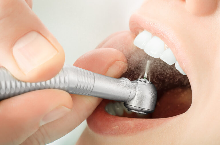 Close up of dentist hand drilling the teeth and spraying the water